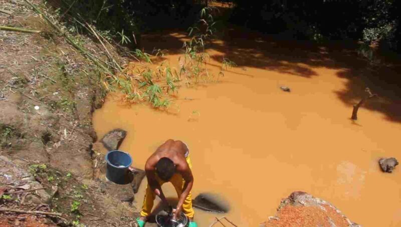 A resident of Aokpasu washing his clothes with the muddy Umabe water at the river bank. This river serves as the major source of water to the community both during dry and rainy seasons.